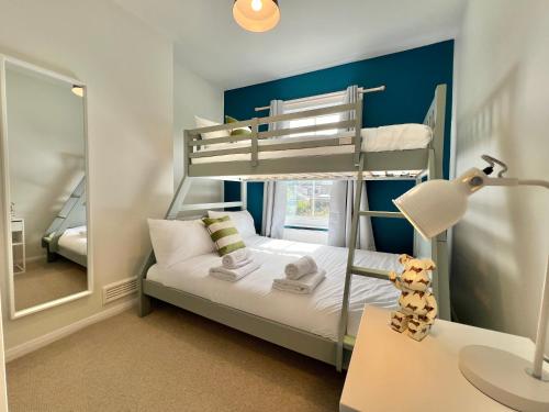 a bedroom with a bunk bed and a desk with a lamp at Charming Central Windsor 2 Bed Cottage Free Residents Parking and Private Garden Legoland Ascot Windsor Castle Thorpe Park Heathrow Airport in Windsor