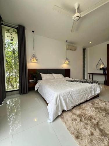 a bedroom with a large bed and a large window at Ivory Mountain Villa in Hòa Bình