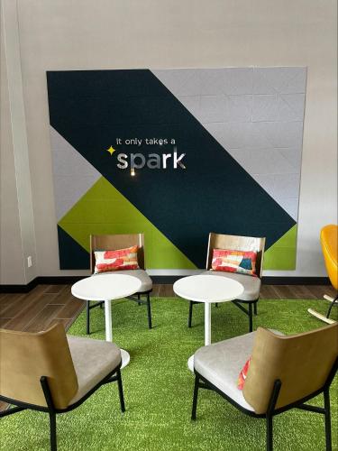 a group of tables and chairs in a room at Spark by Hilton Lancaster Dutch Country in Lancaster