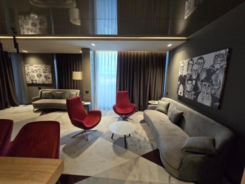 uma sala de estar com um sofá e cadeiras vermelhas em Vojvoda Putnik em Vranje