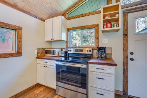 a kitchen with a stove and a microwave at Donnelly Cabin with Fire Pit 5 Mi to Boat and Ski! in Donnelly