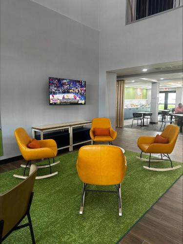 a waiting room with chairs and a tv on a wall at Spark by Hilton Lancaster Dutch Country in Lancaster