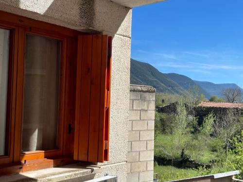 a window on a building with a view of a mountain at Apartamento Temático "The Magic" in Biescas
