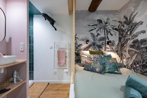 - une chambre avec un lit orné d'une fresque murale de palmiers dans l'établissement Jungle Republic, à Marseille