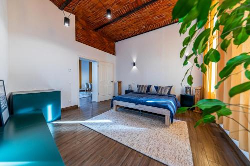 um quarto com uma cama azul e uma mesa em Living&Comfort Luxus-Lofts I Wifi I Smart-TV I quiet I free parking I nur 10min bis zur Innenstadt em Magdeburg