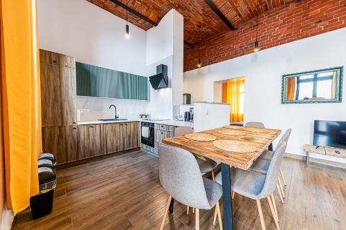 eine Küche und ein Esszimmer mit einem Holztisch und Stühlen in der Unterkunft Living&Comfort Lofts - Rain showers, Wi-fi, Espresso in Magdeburg