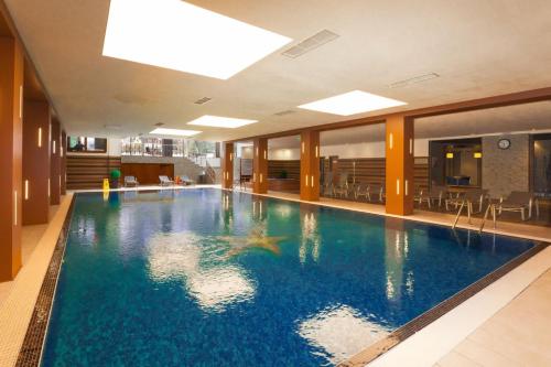 a large swimming pool in a hotel lobby at Cozy Mountain Apartment in Borovets
