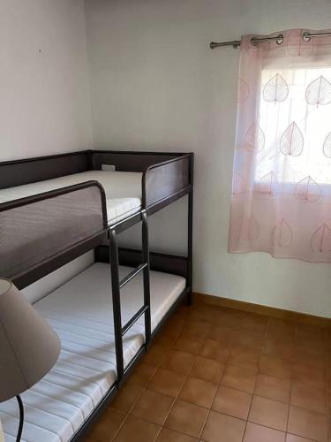 une chambre avec deux lits superposés et une fenêtre dans l'établissement Cocon Familial, à Saint-Raphaël