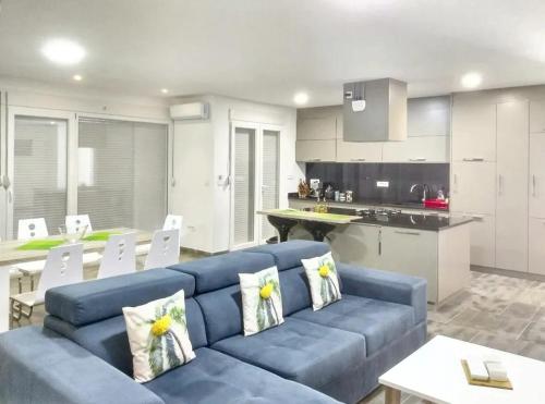 a living room with a blue couch and a kitchen at Charming Villa with Pool, Sea View in Zagora in Zagora