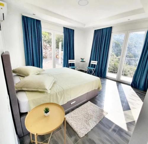Schlafzimmer mit einem großen Bett und blauen Vorhängen in der Unterkunft 3 bedrooms villa at Zagora 40 m away from the beach with sea view private pool and furnished terrace in Zagora