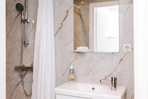 a bathroom with a shower curtain and a sink at Appartement Babette in Zandvoort