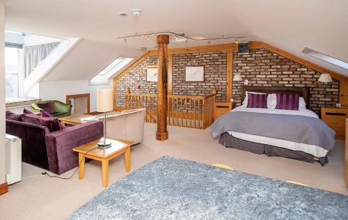 a bedroom with a bed and a brick wall at The Ormond Apartments in Dungarvan