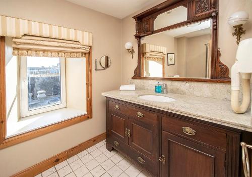 uma casa de banho com um lavatório e um espelho em The Ormond Apartments em Dungarvan