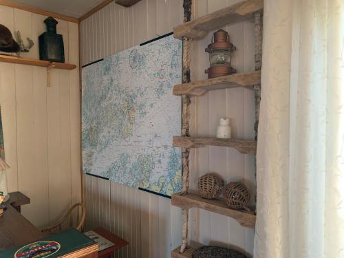 BogøyværにあるMausund Gloettの壁に地図が貼られた部屋の棚