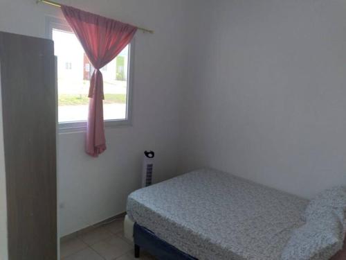 1 dormitorio con cama y ventana en Hacienda 85, en Ahuachapán