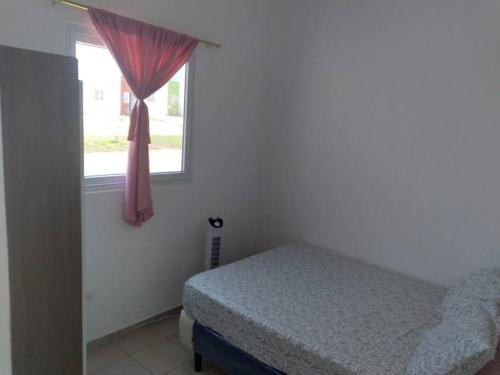 un dormitorio con una cama y una ventana en Hacienda 85, en Ahuachapán