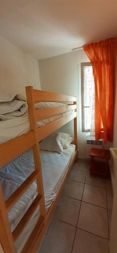 une chambre avec deux lits superposés et une fenêtre dans l'établissement OREE DU GOLF II Joli T3 proche golf piscine Cap d Agde, au Cap d'Agde