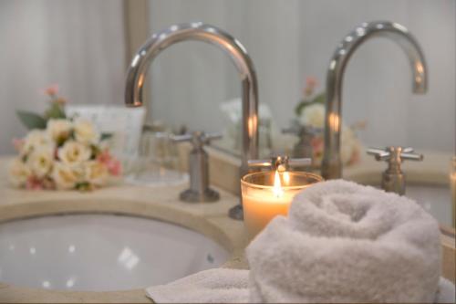 ein Waschbecken mit einer Kerze und einer Badewanne in der Unterkunft Hotel Waldorf in Buenos Aires