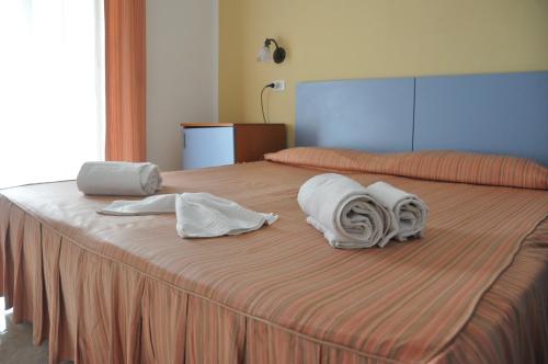 un letto con asciugamani e cuscini sopra di Hotel Le Pelagie a Lampedusa