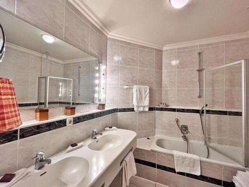 a bathroom with a sink and a bath tub at Hotel Goldener Anker in Bayreuth