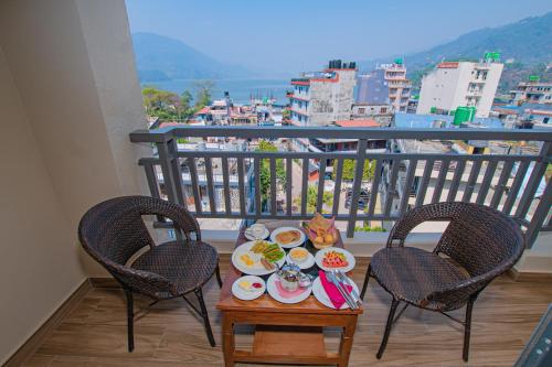 a tray of food on a table on a balcony at Hotel Pokhara Village & SPA in Pokhara