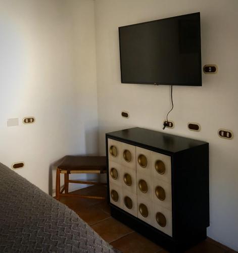 a black dresser with a flat screen tv on a wall at Mestizo Antigua in Antigua Guatemala