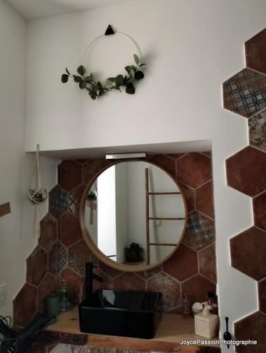 une salle de bain avec un miroir et un lavabo dans l'établissement Chambre d'hôte Au Jardin Le clos des vins d'Anges, à Saint-Pierre-des-Champs
