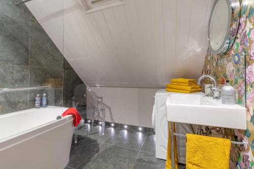 a bathroom with a sink and a bath tub and a mirror at Little Coach House in Beckley