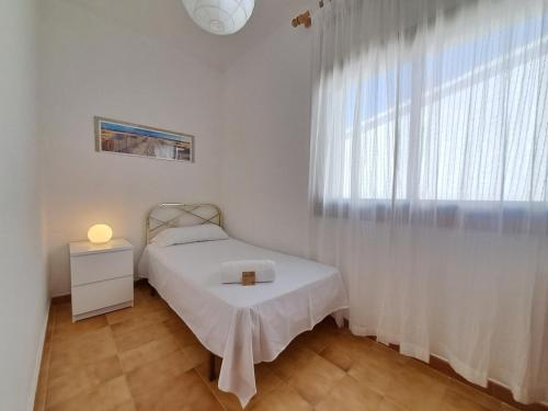 um quarto com uma cama e uma grande janela em HomeHolidaysRentals Owen - Costa Barcelona em Pineda de Mar