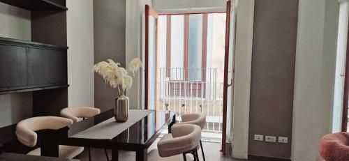 a dining room with a vase of flowers on a table at Maison Michela Sorrento in Sorrento