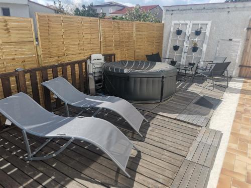 a patio with two chairs and a large tub at Appartement, prive terrasse, parking et jardin in Le Boulou