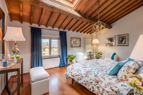 a bedroom with a bed and a desk and a window at De Nobili Penthouse Apartment with Elevator in Lucca in Lucca