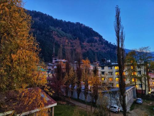 a view of a city with a mountain in the background at Surya International Hotel Manali near Mall Road in Manāli