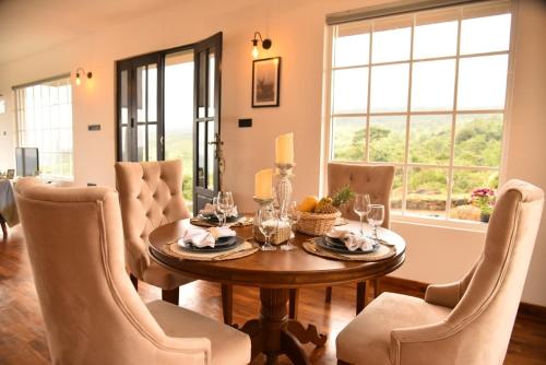 uma sala de jantar com uma mesa de madeira e cadeiras em Thumpers Cottage em Kalawana