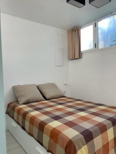 een slaapkamer met een bed met een geruite deken bij Esmeralda in Palma de Mallorca