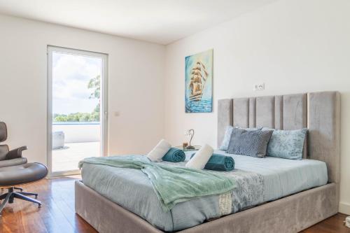 a bedroom with a large bed with blue pillows at Azores Dreams - Sea View House in São Roque