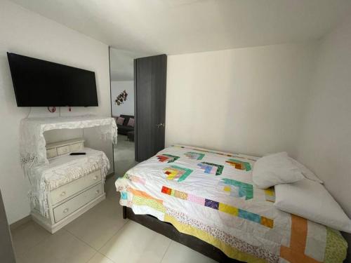 - une chambre avec un lit et une télévision à écran plat dans l'établissement Amplio apartamento en el centro!, à Pereira