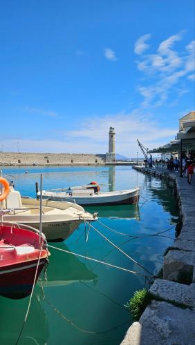 a group of boats docked at a dock with a lighthouse at Gardenia - Morfi Village with pool in Exopoli