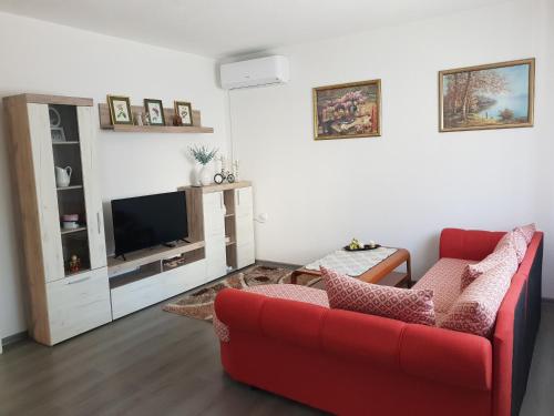 ModričaにあるApartman Centarの赤いソファとテレビのあるリビングルーム