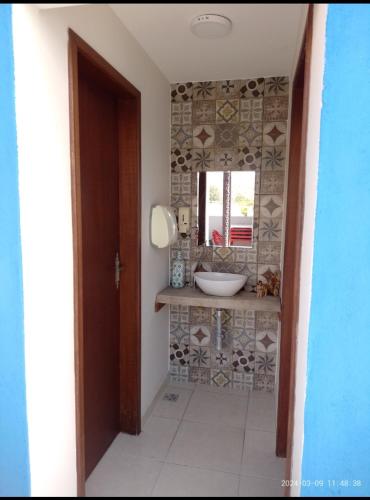 een badkamer met een wastafel en een spiegel bij Pousada Mundo Novo in Aparecida