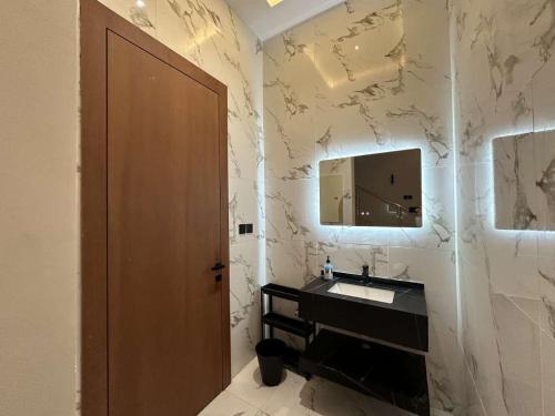 ein Bad mit einem Waschbecken und einem Spiegel in der Unterkunft ابيات فيلا in Riad