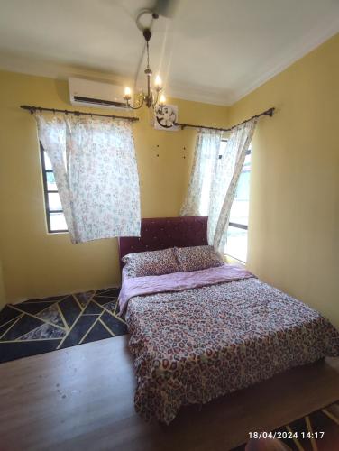 a bedroom with a bed and two windows at Homestay Zamzam in Bachok