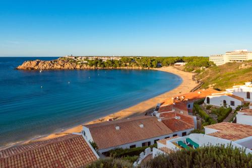 eine Luftansicht auf einen Strand mit Gebäuden und das Meer in der Unterkunft sol isla surf house 223 in Arenal d'en Castell