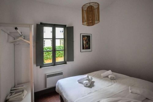 um quarto com uma cama branca e uma janela em L'Enclave em Avignon