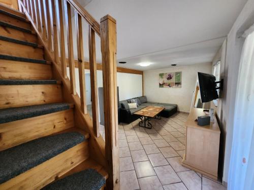 a living room with a staircase and a couch at Gästehaus Parkblick in Rust
