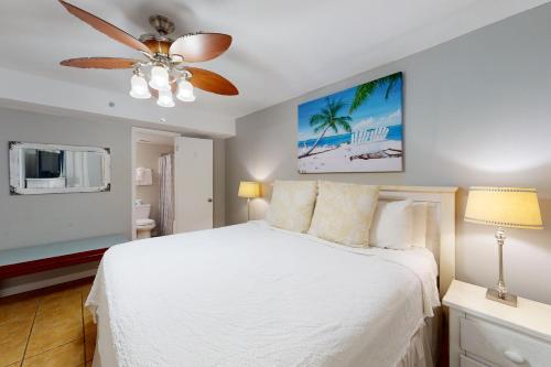 a bedroom with a white bed and a ceiling fan at Phoenix VI 807 in Orange Beach