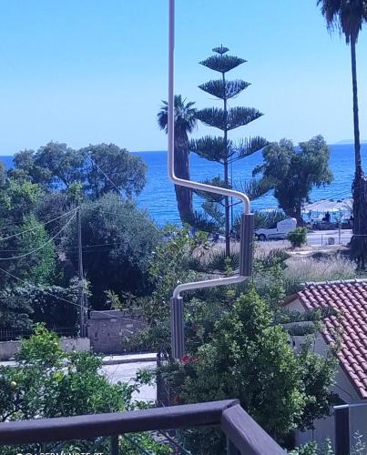 einen Blick auf das Meer von einem Resort mit einem Baum in der Unterkunft Lenia's seaside apartment in Faraí