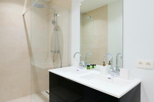 a bathroom with a sink and a shower at The Nations Bois de la Cambre Flats in Brussels