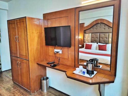 a hotel room with a bed and a mirror at Surya International Hotel Manali near Mall Road in Manāli