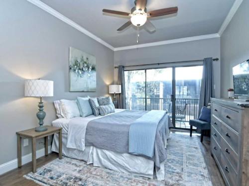 a bedroom with a bed with a ceiling fan and a balcony at Comal Rive Pool Gruene Hall by Barclé in New Braunfels